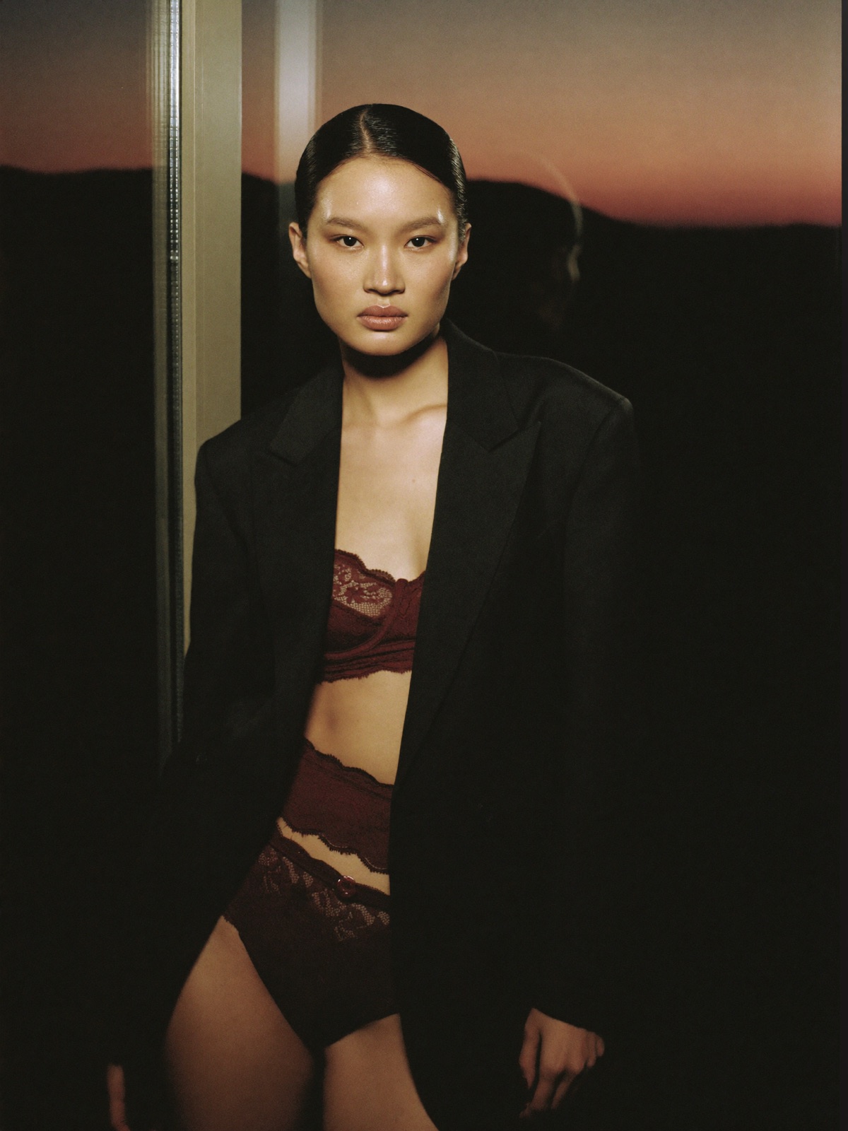 AI-generated editorial portrait in burgundy lace under an oversized blazer